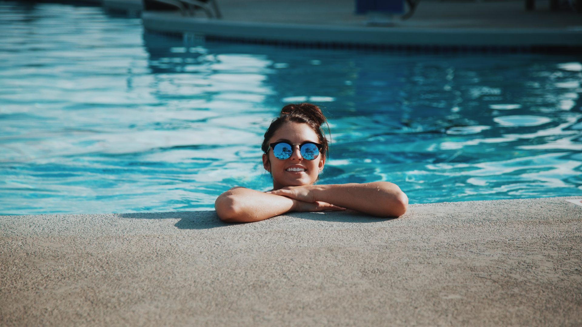 woman wearing sunglasses on swimming pool during daytime